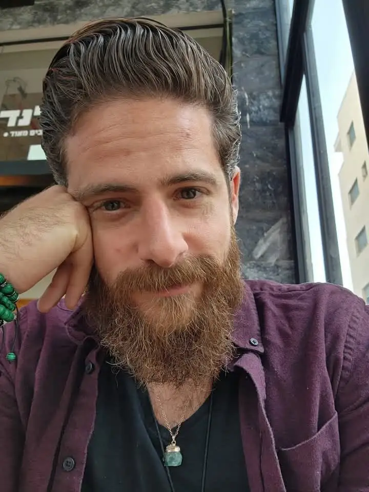 אמיר גיגי נשען על היד ומחייך